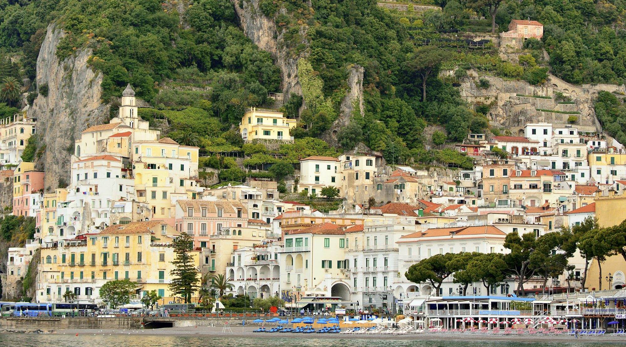 A speedboat running fast along the Amalfi Coast with the cliffs behind