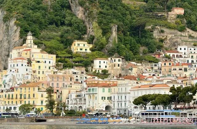 A speedboat running fast along the Amalfi Coast with the cliffs behind