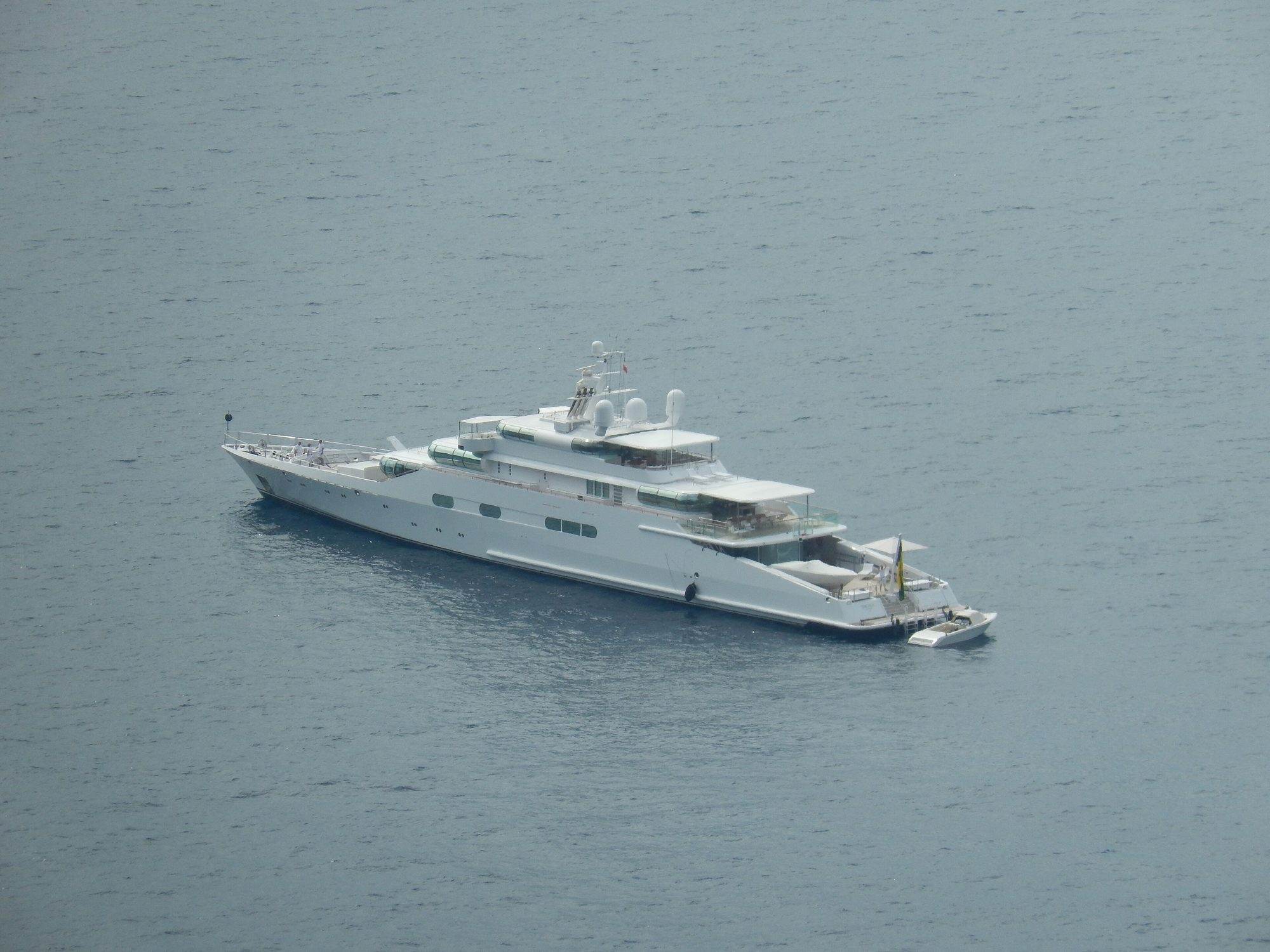 Motor boat anchored off the Capri coastline with blue water and cliffs behind
