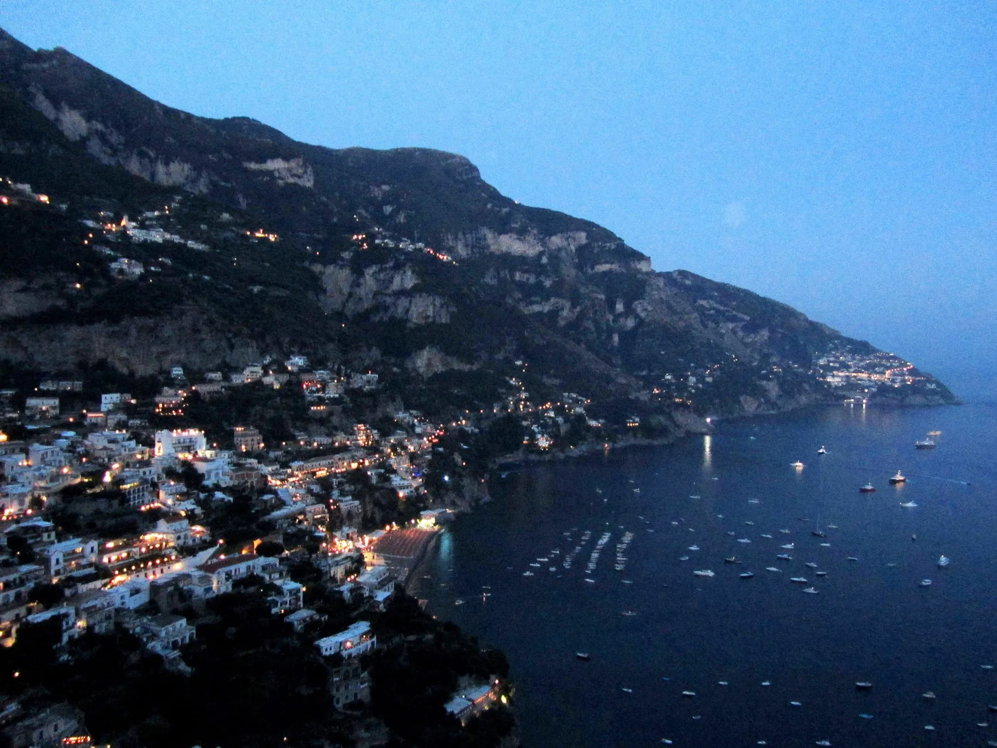 Positano lit up at night seen from below